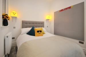 a bedroom with a white bed with a yellow pillow at Macatsim Seaview Sunset in Margate