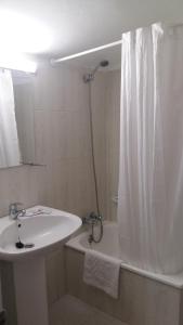 baño con lavabo y cortina de ducha en Pensión El Tabanu, en Celorio