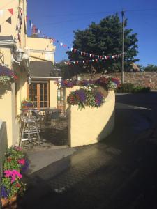 a building with flower boxes on the side of a street at The Captains in St Martin Guernsey
