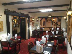 uma sala de jantar com mesas e cadeiras num restaurante em The Captains em St Martin Guernsey