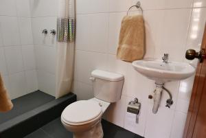 a bathroom with a toilet and a sink at Hotel Norte in Cuenca