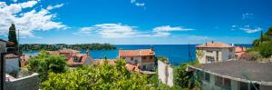 a group of buildings with the ocean in the background at Monte Holiday Home with Jacuzzi in Rovinj