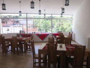 a dining room with tables and chairs and a large window at Terraza de Luna in Machu Picchu
