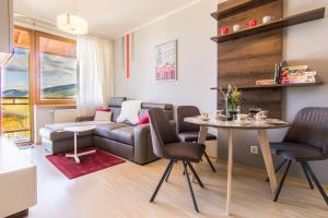 a living room with a couch and a table at Apartamenty Viva Maria Zakopane in Zakopane