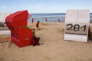 ヴァンガーラントにあるTraberhofのビーチには椅子が2脚あり、ビーチには人がいます。