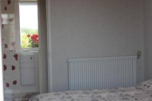 a white bed in a white room next to a window at Au p'tit Mont in Ardevon