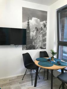 グダニスクにあるBrovar City Centre Apartamentのダイニングルーム(テーブル、椅子、時計台付)