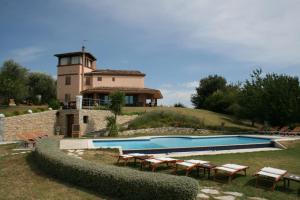 a house with a swimming pool in front of a building at Relais Il Monticello in Montefiore Conca