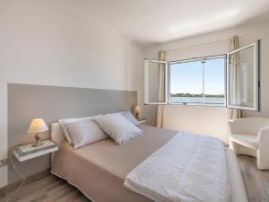 - une chambre blanche avec un lit et une fenêtre dans l'établissement Panoramic Studio Carloforte, à Carloforte