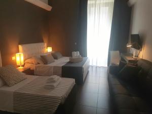 una camera d'albergo con due letti e una finestra di Ottomood Ala Ovest Catania Centro a Catania