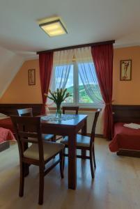 Un comedor con mesa y sillas y una ventana. en Pensjonat Willa Szarotka, en Kluszkowce