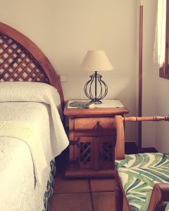 a bedroom with a bed and a table with a lamp at Posada Las Garzas in Santoña