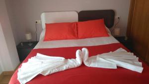 サンシェンショにあるApartamento Lanzada Luxe - Sanxenxoruralの赤と白のベッド(白の服付)