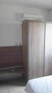 1 dormitorio con armario de madera y cama en Apartamento no Riviera Park, en Caldas Novas