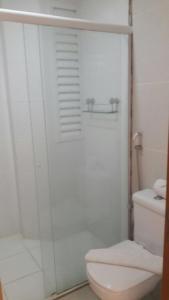 y baño blanco con aseo y ducha. en Apartamento no Riviera Park, en Caldas Novas