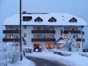 een groot gebouw met sneeuw op de grond bij Hotel Drei Konige in Schramberg