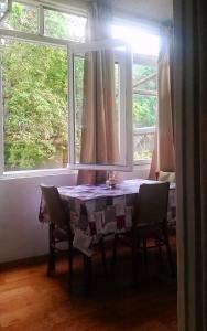 einen Tisch mit Stühlen in einem Zimmer mit Fenstern in der Unterkunft Manana Appartment in Tbilisi City