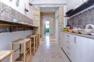 una cucina con mobili bianchi e sgabelli da bar di B&B Villa Ida Pescara Centro a Pescara