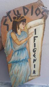 a painting of a woman holding a sign at Ifigenia Studios in Patitiri