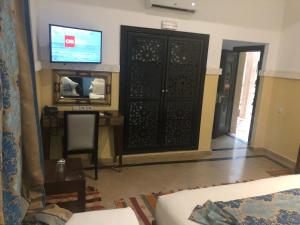 sala de estar con puerta negra y TV en Riad Nesma Suites & Spa, en Marrakech