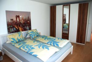 a bedroom with a bed with blue and white pillows at FeWo Ulamec Appartment VI in Velden am Wörthersee