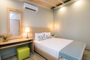 ein Schlafzimmer mit einem weißen Bett, einem Fenster und einem grünen Stuhl in der Unterkunft Romantic Apartment in Skala Kallirachis