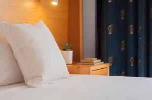 a white pillow sitting on top of a bed at Alexandra Hotel in St. Julianʼs
