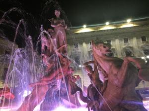 a fountain with people playing in it at night at Le Casette Gargallo 2 - Ortigia in Siracusa