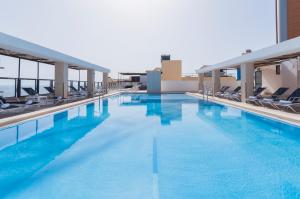 una piscina con acqua blu in un edificio di Alexandra Hotel a San Giuliano