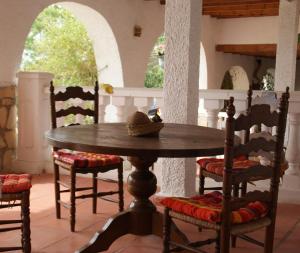 a wooden table and chairs with a hat on top at Casas Rurales Delfos in Villajoyosa