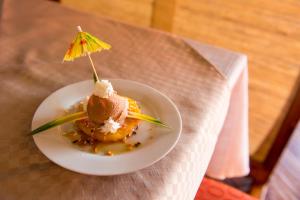 a dessert on a plate with an umbrella on it at Ivotel in Antananarivo