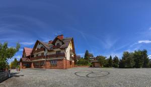 a large house sitting on top of a driveway at Pensjonat Willa Szarotka in Kluszkowce