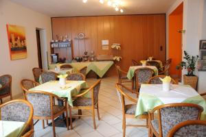 ein Restaurant mit Tischen und Stühlen und einer Theke in der Unterkunft Pension Erlaa in Wien