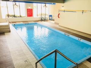 a large swimming pool with blue water in a building at BA Hotel in Red Deer