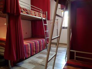 a red bunk bed sitting next to a red wall at Horta Grande in Silves