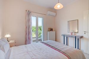 a white bedroom with a bed and a window at Villa Rosemagnolia, pool 35m2, in green, gardens, full sun close to everything in Ayiá +24 photos