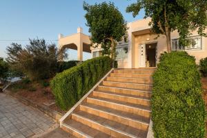 a house with stairs leading to the front door at Villa Rosemagnolia, pool 35m2, in green, gardens, full sun close to everything in Ayiá