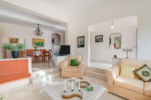 a living room with furniture and a dining room at Villa Rosemagnolia, pool 35m2, in green, gardens, full sun close to everything in Ayiá