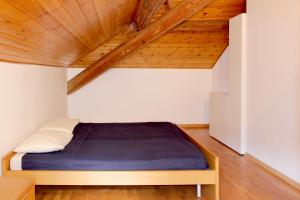 Posto letto in camera con soffitto in legno. di Bellagio Ghisallo Penthouse a Bellagio