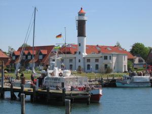 a group of boats docked at a dock with a lighthouse at Ferien auf der Insel Poel in Kirchdorf