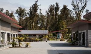 a group of buildings with trees in the background at 58 On Cron Motel in Franz Josef