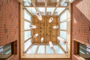 a room with windows and lights on the wall at West Court- Jesus College in Cambridge