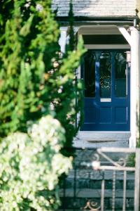una porta blu su una casa con una recinzione di Rum Doodle, Windermere B&B a Windermere