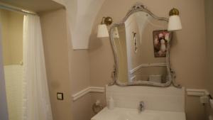baño con espejo y lavabo en LANTIGUA CASA RURAL en Hinojosa del Duque