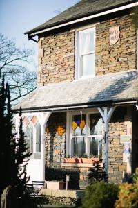 Una casa de ladrillo con una ventana con un cartel. en Rum Doodle, Windermere B&B en Windermere