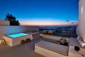 a rooftop patio with a jacuzzi tub on a building at White & Co. La Torre Suites in Pirgos