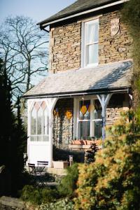 Casa de ladrillo con puerta blanca y ventanas en Rum Doodle, Windermere B&B, en Windermere