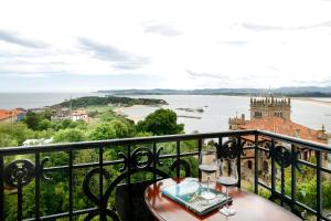 uma varanda com uma mesa e vista para a água em Eurostars Hotel Real em Santander