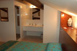 a bathroom with a bed and a sink and a mirror at Le Mas Ferrand in Graveson +133 photos