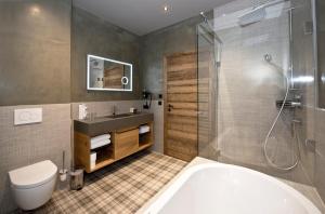 a bathroom with a tub and a sink and a shower at Postresidenz in Mayrhofen +37 photos